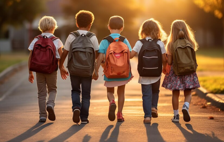 cinque bambini camminano di spalle verso la scuola
