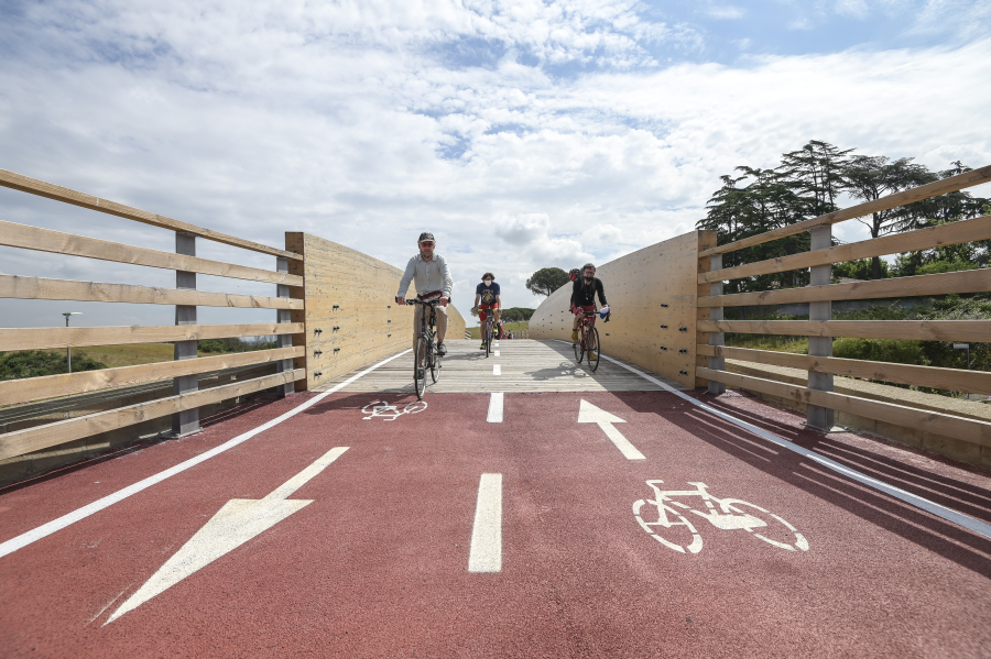Tre persone viaggiano in bici su una pista ciclabile